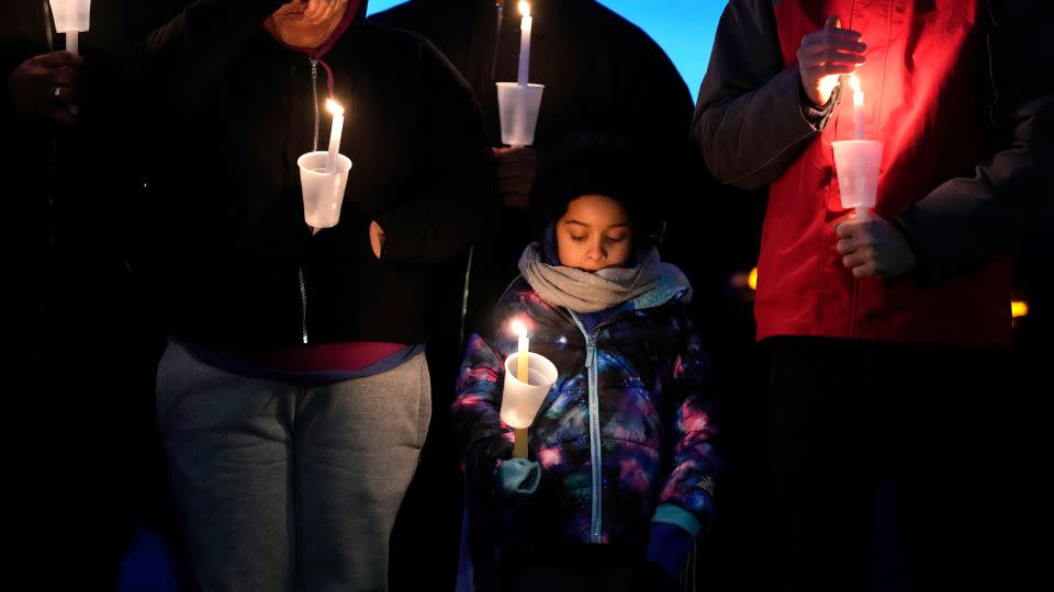 Residents pray during a candlelight vigil following a shooting at Perry High School in Perry, Iowa, on Thursday, January 4. - Charlie Neibergall/AP
