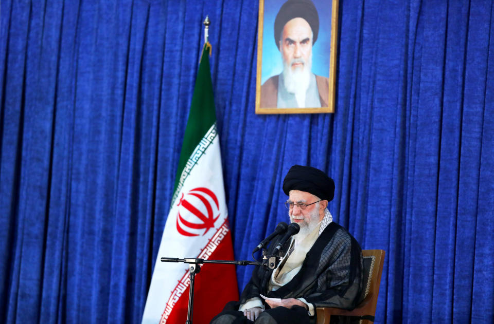 In this photo released by an official website of the office of the Iranian supreme leader, Supreme Leader Ayatollah Ali Khamenei speaks on the anniversary of the death of the late founder of the Islamic Republic, Ayatollah Ruhollah Khomeini, shown in the poster at top center, at his mausoleum in Tehran, Iran, Saturday, June 4, 2022. Khamenei acknowledged Saturday that Iran took the oil from two Greek tankers last month in helicopter-launched raids in the Persian Gulf. (Office of the Iranian Supreme Leader via AP)