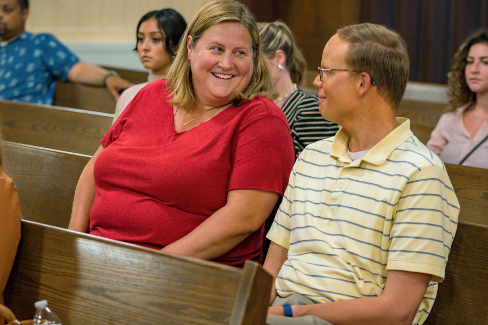 a man and a woman smile at each other in a church