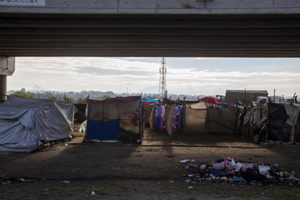 People who lost their homes in last year's hurricanes Eta and Iota live under tarps they set up under a bridge on the outskirts of San Pedro Sula, Honduras, Monday, Jan. 11, 2021. President Joe Biden has promised investment in Central America to get at the root causes of immigration, but no one expects to see any change soon. (AP Photo/Moises Castillo)