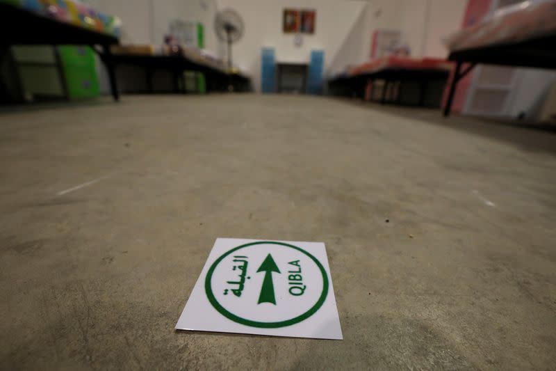 A sign that shows the prayer direction for Muslims is pictured in a room at Changi Exhibition Centre which has been repurposed into a community isolation facility, in Singapore