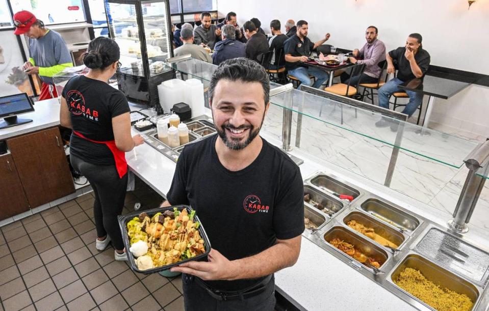 Hafed Alwajih of Kabab Time holds up a made-to-order plate featuring a selection of three proteins, sauces and toppings.