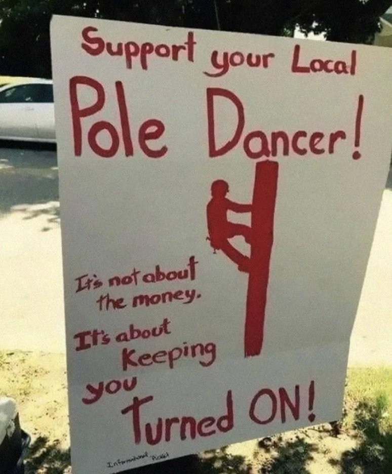 Sign reads "Support your Local Pole Dancer!" with humorous subtext about keeping people energized