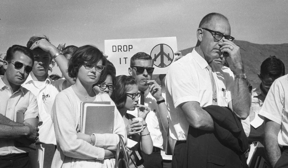 About 350 people attended a Cal Poly debate on the Vietnam War on Oct. 21, 1965. A student holds a placard that has a bomber in the shape of a peace sign and the words “Drop It.”