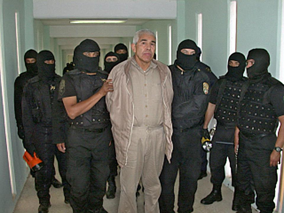 In this file handout picture released by the Mexican Federal Preventive Police (PFP) on January 29, 2005, members of the PFP escort drug trafficker Rafael Caro Quintero, at the Puente Grande prion in Guadalajara, Jalisco State, Mexico.