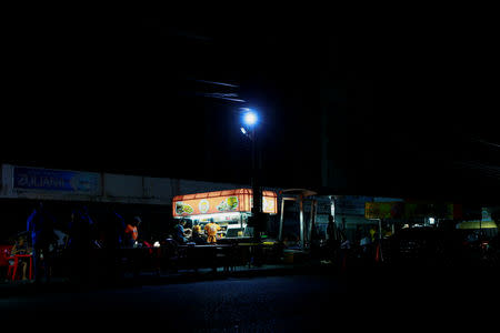 Street food vendors whose stalls' power is supplied by generators, work during a blackout in Maracaibo, Venezuela March 31, 2019. REUTERS/Isaac Urrutia