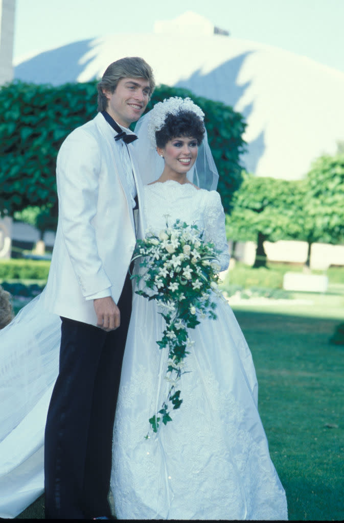 Marie and Steve in wedding attire with veil and tuxedo, smiling outdoors