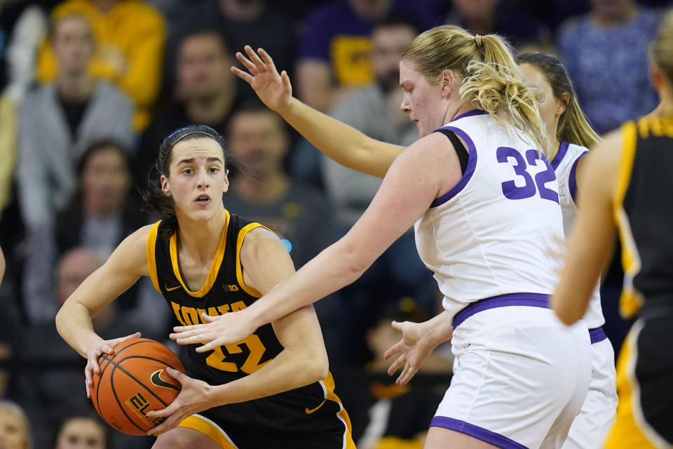 Iowa guard Caitlin Clark (22) passes around Northern Iowa center Rachael Heittola (32) during the first half of an NCAA college basketball game, Sunday, Nov. 12, 2023, in Cedar Falls, Iowa. (AP Photo/Charlie Neibergall)