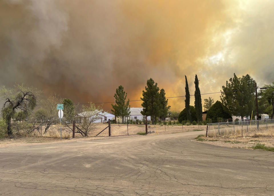 In this Thursday, April 8, 2021, photo provided by Arizona Department of Forestry & Fire Management shows, homes near the intersection of Church Rd and N Dudleyville Rd as the Pinal County Wildfire burns near Dudleyville, Ariz. A small community in south-central Arizona remained under an evacuation notice Friday after crews and air tankers stopped the growth of a wildfire that burned at least 12 homes, officials said. (Arizona Department of Forestry & Fire Management via AP)