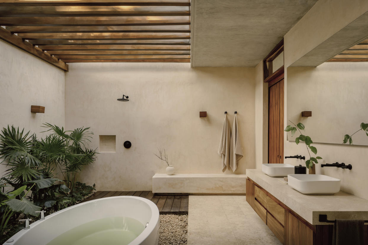 An outdoor bathroom with rough walls and a bathtub. 