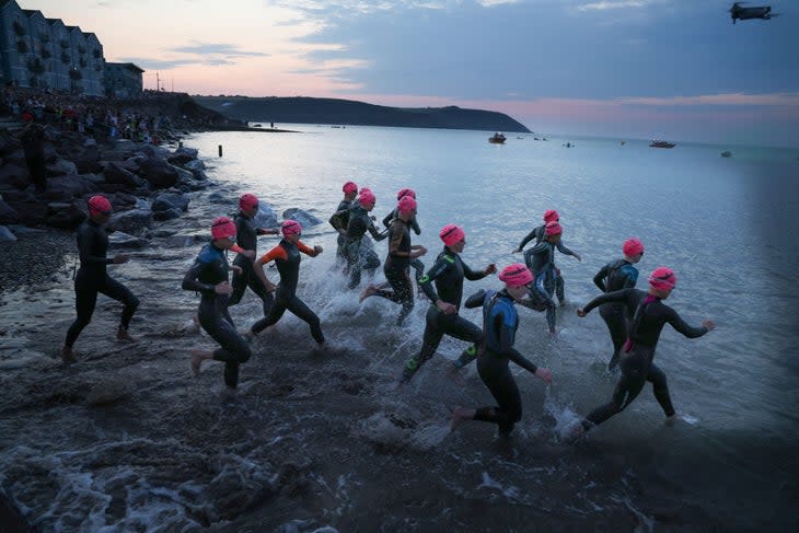 Women enter the water at the start of an Ironman. With > Against hopes to elevate competition in triathlon