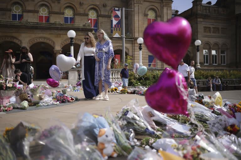 Flores y tributos se colocan fuera del Centro de Arte Atkinson Southport en Southport, Inglaterra, miércoles, 31 de julio de 2024, después de que tres niñas murieran en un ataque con cuchillo en un club de vacaciones temático de Taylor Swift el lunes.