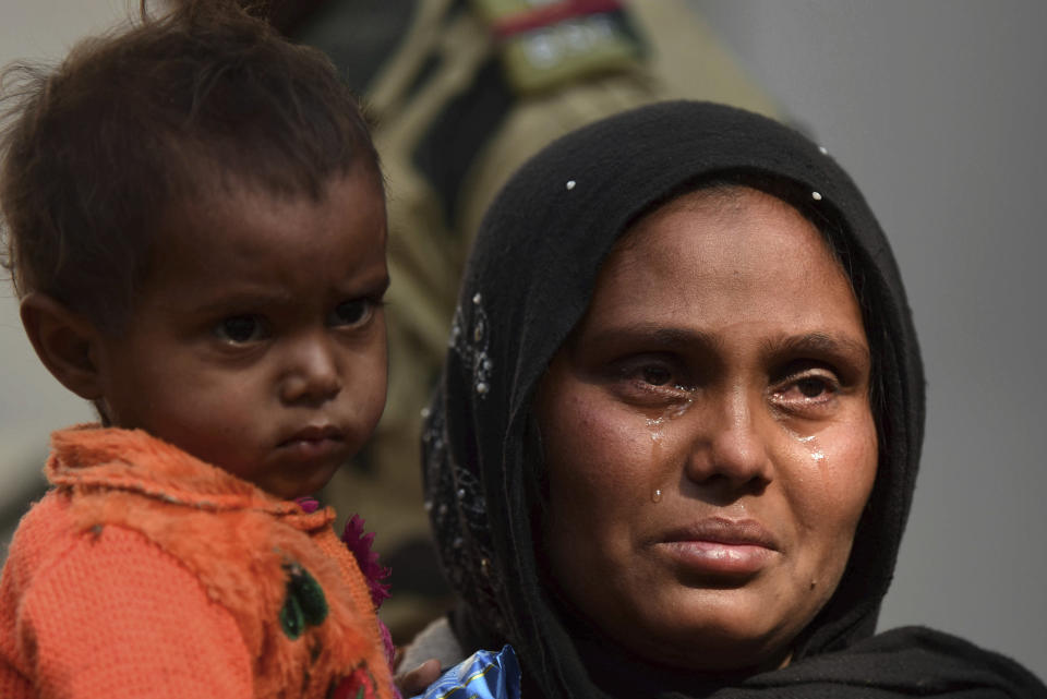 A Rohingya Muslim woman cries as she holds a child after they were arrested, outside a police station in Agartala, India, Tuesday, Jan. 22, 2019. Police in northeastern India say they have arrested 61 Rohingya Muslims this week amid reports that more than 1,300 have recently crossed the border into Bangladesh. (AP Photo/Abhisek Saha)