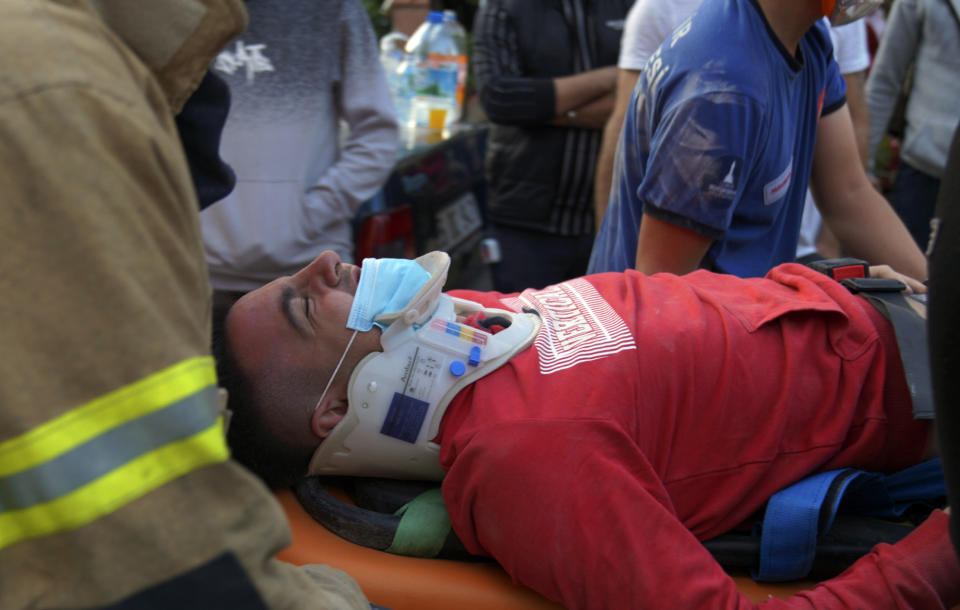 Rescuers carry a man rescued from the debris of his collapsed house, in Izmir, Turkey, Friday Oct. 30, 2020. A strong earthquake struck Friday in the Aegean Sea between the Turkish coast and the Greek island of Samos, killing several people and injuring hundreds amid collapsed buildings and flooding. (Ali Ihsan Mimtas/Depo Photos via AP)