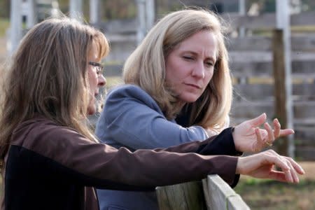 FILE PHOTO: Virginia Democratic candidate for U.S. Representative Abigail Spanberger (R) talks with Jorg Huckabee-Mayfield during a visit to the horse rescue stables she and her husband operate in Burkeville, Virginia, U.S. October 31, 2018. REUTERS/Jonathan Ernst/File Photo