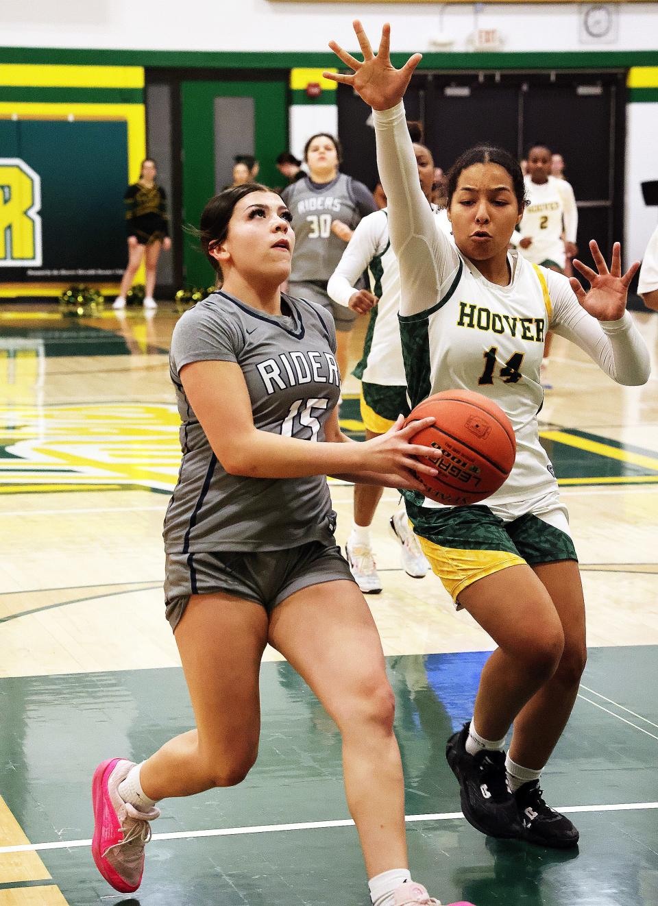Roosevelt freshman Tess Ryan (15) drives the lane against Hoover senior guard Alayna Jarrett (14) on Friday. Roosevelt is above .500 on the season with Friday's win.