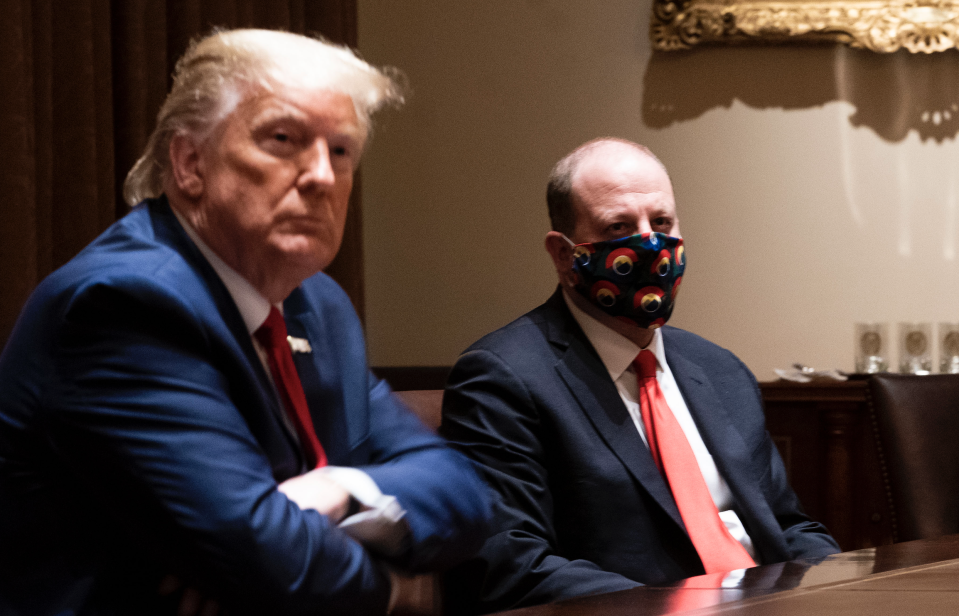 Colorado Governor Jared Polis (C) wears a face mask as U.S. President Donald Trump makes remarks during a meeting in the Cabinet Room of the White House, May 13, 2020 in Washington, DC. (Photo: Doug Mills-Pool/Getty Images)