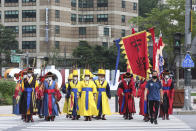 South Korean Imperial guards wearing face masks to help protect against the spread of the coronavirus cross a road in Seoul, South Korea, Wednesday, Aug. 5, 2020. (AP Photo/Ahn Young-joon)
