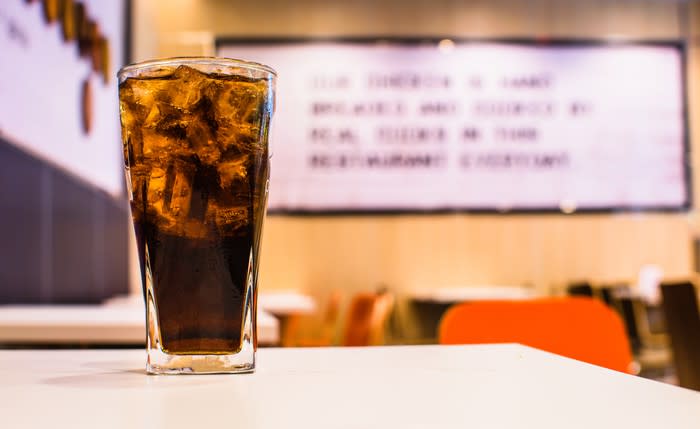 A glass of cola on a table.