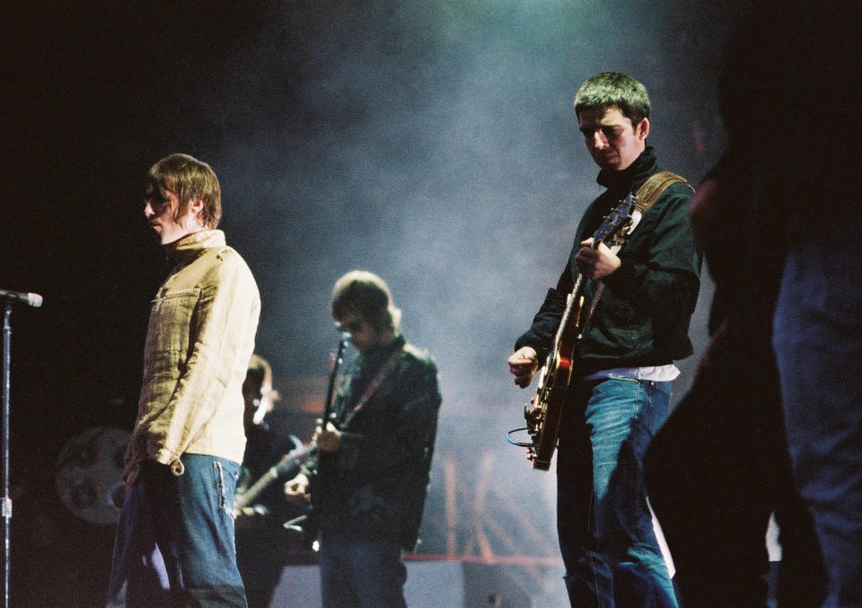 LONDON, UNITED KINGDOM - JULY 06: Liam Gallagher and Noel Gallagher of Oasis perform on stage in Finsbury Park, on July 6th 2002, London, England. (Photo by Pete Still/Redferns)