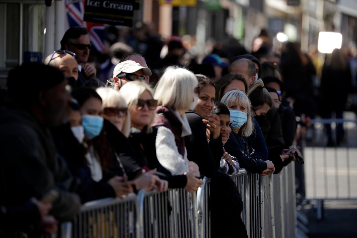 People wait by barriers outside Windsor Castle ahead of the funeral of Britain's Prince Philip in Windsor, England, Saturday, April 17, 2021.