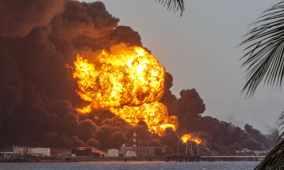 Flames and smoke rise from the Matanzas Supertanker Base as firefighters work to quell the blaze which began during a thunderstorm in Matanzas, Cuba, Monday, Aug. 8, 2022. Cuban authorities say lightning struck a crude oil storage tank at the base, sparking a fire that sparked four explosions. (AP Photo/Ismael Francisco)