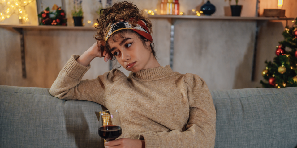 woman looking sad holding wine