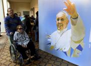 People leave after signing coconuts - part of an altar to be used by Pope Francis in an open mass at the Nu Guazu camp during his upcoming visit, in Asuncion, Paraguay, on July 4, 2015