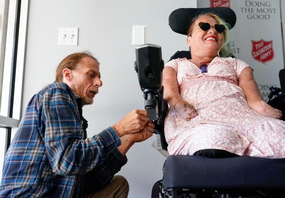 Danny Beer adjusts the arm of his wife AngieÕs new electric wheelchair as she smiles at the Salvation Army in Naples on Wednesday, Feb. 15, 2023. 