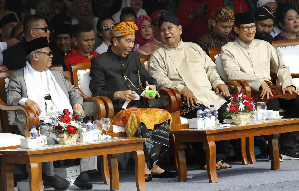 Indonesian President Joko Widodo, second left, and his running mate Ma'ruf Amin, left, and his contender Prabowo Subianto, second right, with his running mate Sandiaga Uno, right, during a ceremony marking the kick off of the campaign period for next year's election in Jakarta, Indonesia, Sunday, Sept. 23, 2018. Indonesia is set to hold its presidential and parliamentary election poll in April 2019.(AP Photo/Tatan Syuflana)