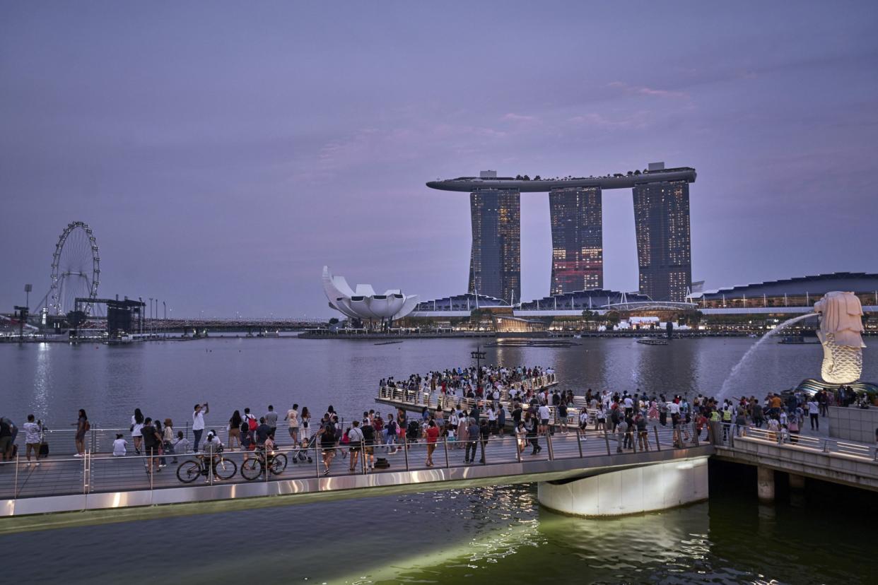 Crowds by the Merlion and Marina Bay Sands in Singapore, on Saturday, July 9, 2022. Singapore is scheduled to announce its second quarter advanced gross domestic product (GDP) estimate on July 14, 2022. Singapore is scheduled to release second quarter advance gross domestic product (GDP) estimates on July 14. Photographer: Lauryn Ishak/Bloomberg