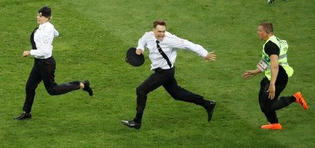 Soccer Football - World Cup - Final - France v Croatia - Luzhniki Stadium, Moscow, Russia - July 15, 2018 Pitch invaders are chased by a steward during the match REUTERS/Christian Hartmann