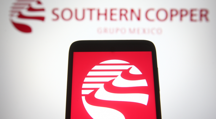 Southern Copper Corporation logo on a phone screen in front of the logo on a computer screen. SCCO stock.