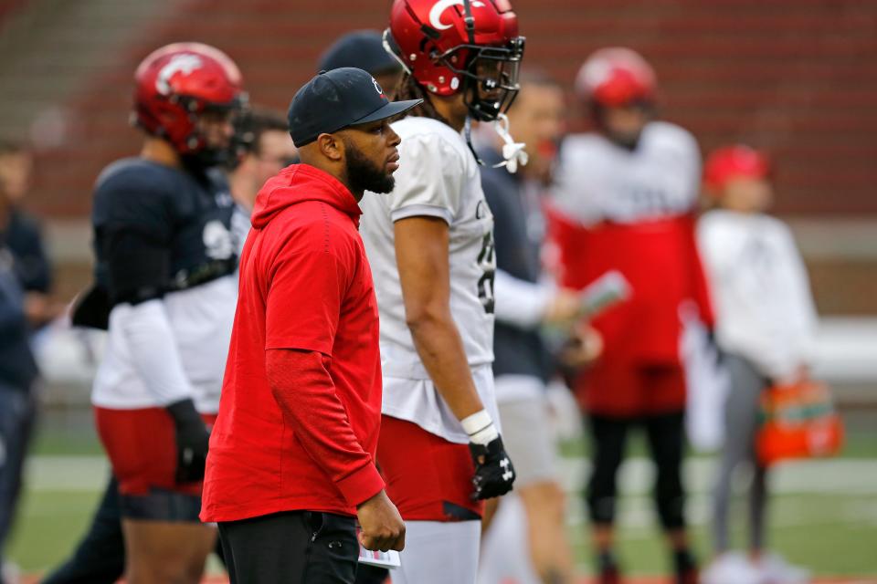 Wide receivers coach Mike Brown oversees drills during a spring practice at Nippert Stadium in Cincinnati on Thursday, March 24, 2022.