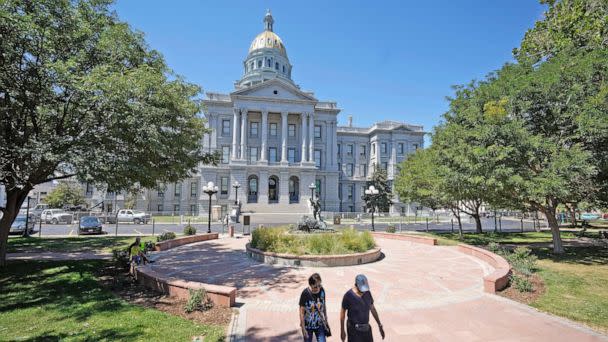 PHOTO: People walk outside the State Capitol on Aug. 30, 2022, in Denver. (David Zalubowski/AP)