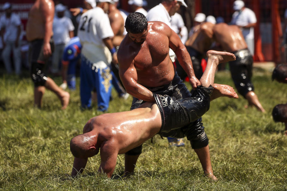 Wrestlers, doused in olive oil, compete during the 660th instalment of the annual Historic Kirkpinar Oil Wrestling championship, in Edirne, northwestern Turkey, Saturday, July 10, 2021.Thousands of Turkish wrestling fans flocked to the country's Greek border province to watch the championship of the sport that dates to the 14th century, after last year's contest was cancelled due to the coronavirus pandemic. The festival, one of the world's oldest wrestling events, was listed as an intangible cultural heritage event by UNESCO in 2010. (AP Photo/Emrah Gurel)