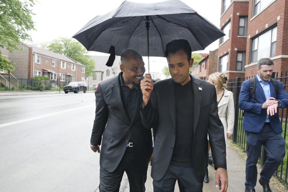 Republican Presidential candidate Vivek Ramaswamy right, speaks with former inmate and author Tyrone Muhammad left, while walking to the shuddered former South Shore High School where the city of Chicago plans to house illegal immigrants Friday, May 19, 2023, in Chicago. (AP Photo/Paul Beaty)