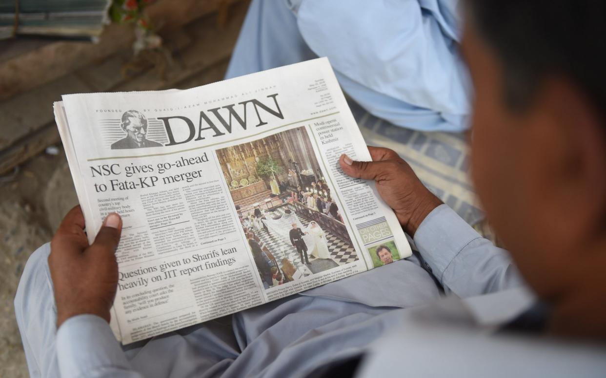 A Pakistan man reads a copy of the Dawn English-language newspaper at a newspaper stall in Karachi on May 20 - AFP