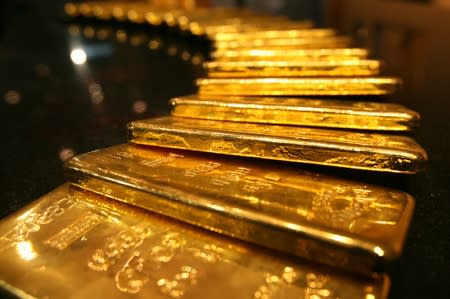 Gold prices edged lower on Monday as the dollar stayed firm ahead of the Fed meeting later this week