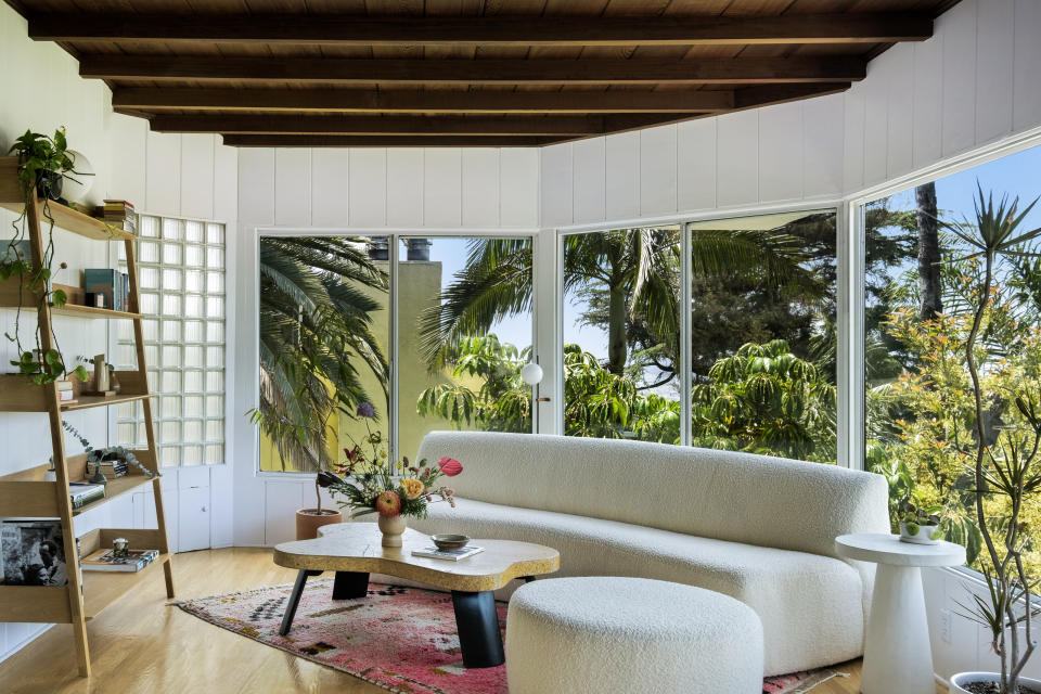 A living area with a white curved boucle sofa