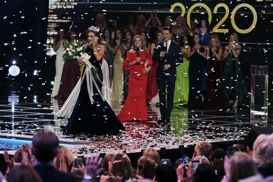 FILE - In this Dec. 19, 2019, file photo, Camille Schrier, of Virginia, left, reacts after winning the Miss America competition at the Mohegan Sun casino in Uncasville, Conn. The 100th Miss America will be crowned before a live audience at the Mohegan Sun casino in Connecticut following a year of virtual appearances and postponed competitions due to the pandemic, organizers announced Thursday, April 8, 2021. (AP Photo/Charles Krupa, File)