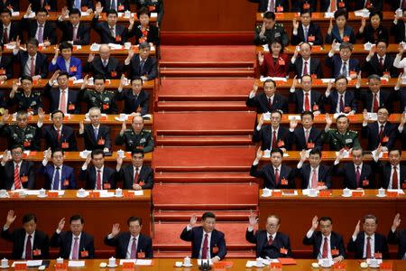 Chinese President Xi Jinping (front row, center) and fellow delegates raise their hands as they take a vote at the closing session of the 19th National Congress of the Communist Party of China, in Beijing, China October 24, 2017. REUTERS/Thomas Peter