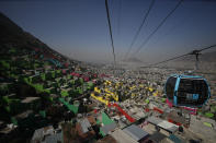 Officials and journalists ride in cable cars between the Campos Revolucion and Tlalpexco stations, during the inauguration of a new aerial public transit system dubbed the Cablebus, in the Cuautepec neighborhood of northern Mexico City, Thursday, March 4, 2021. For the residents of Cuautepec, this new system, the first of four planned lines, will turn a commute to the nearest subway station, that can last up to two hours, into a 30-minute ride. (AP Photo/Rebecca Blackwell)