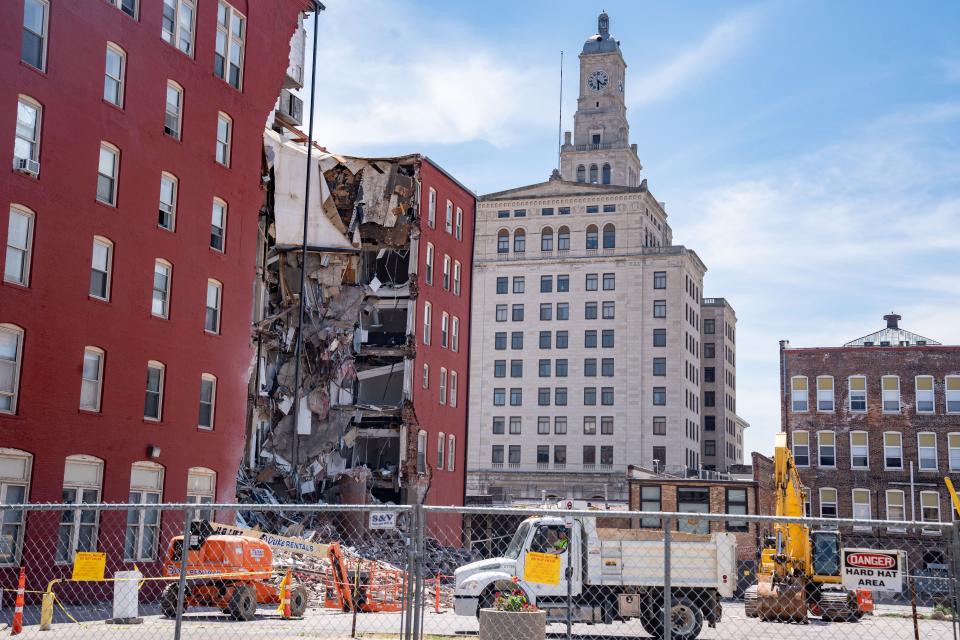 Workers secure the area a day after an apartment building partially collapsed in Davenport, Monday, May 29, 2023.
