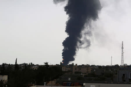 Plumes of smoke rise in the sky after a rocket hit a fuel storage tank near the airport road in Tripoli, during clashes between rival militias July 28, 2014. REUTERS/Hani Amara