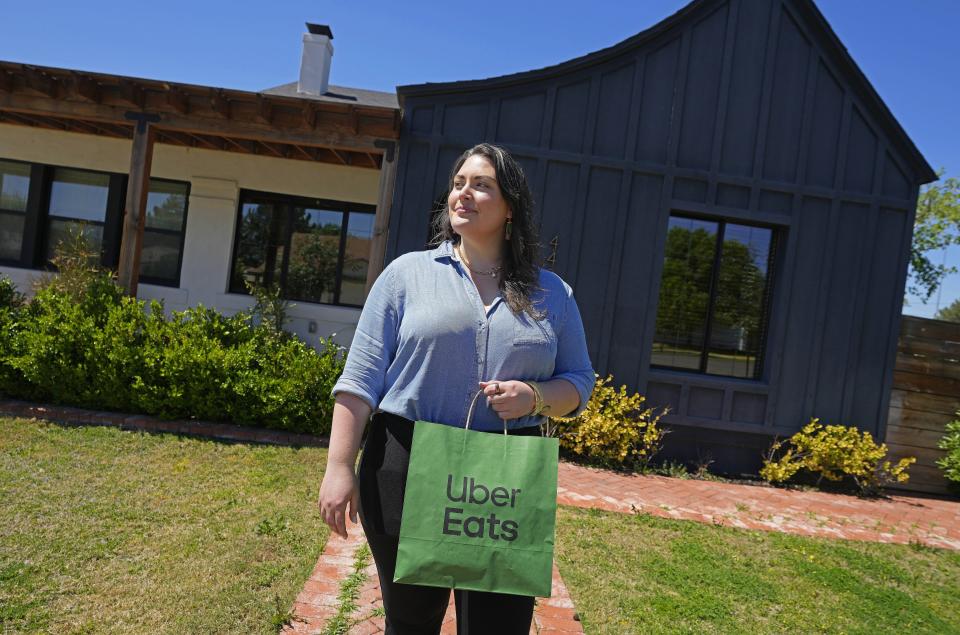 Amanda Ventura, public affairs manager at Waymo, holds an order from Princess Pita delivered by a fully autonomous Waymo car via Uber Eats in Mesa on April 3, 2024.