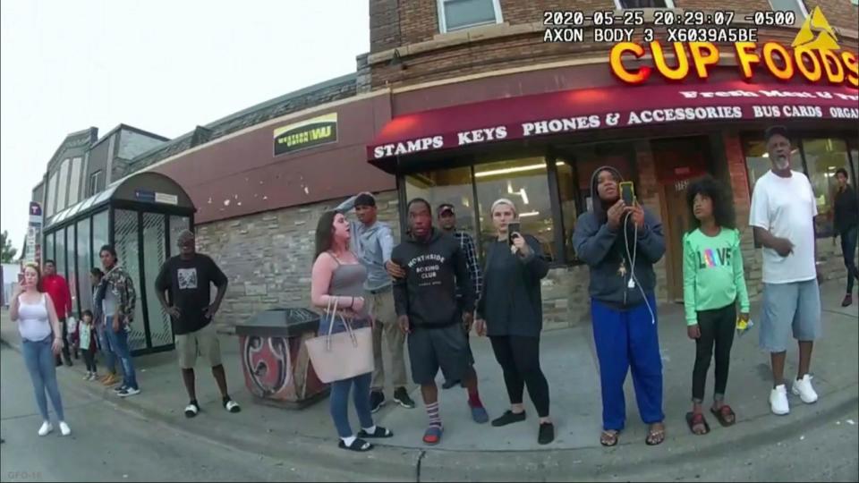 Police body camera footage shows bystanders watching police officer Derek Chauvin subdue George Floyd in Minneapolis, including Alyssa Funari, left, filming; Charles McMillian, center left in light-colored shorts; Christopher Martin, center in gray; Donald Williams, center in black; Genevieve Hansen, fourth from right, filming; and Darnella Frazier, third from right, filming.