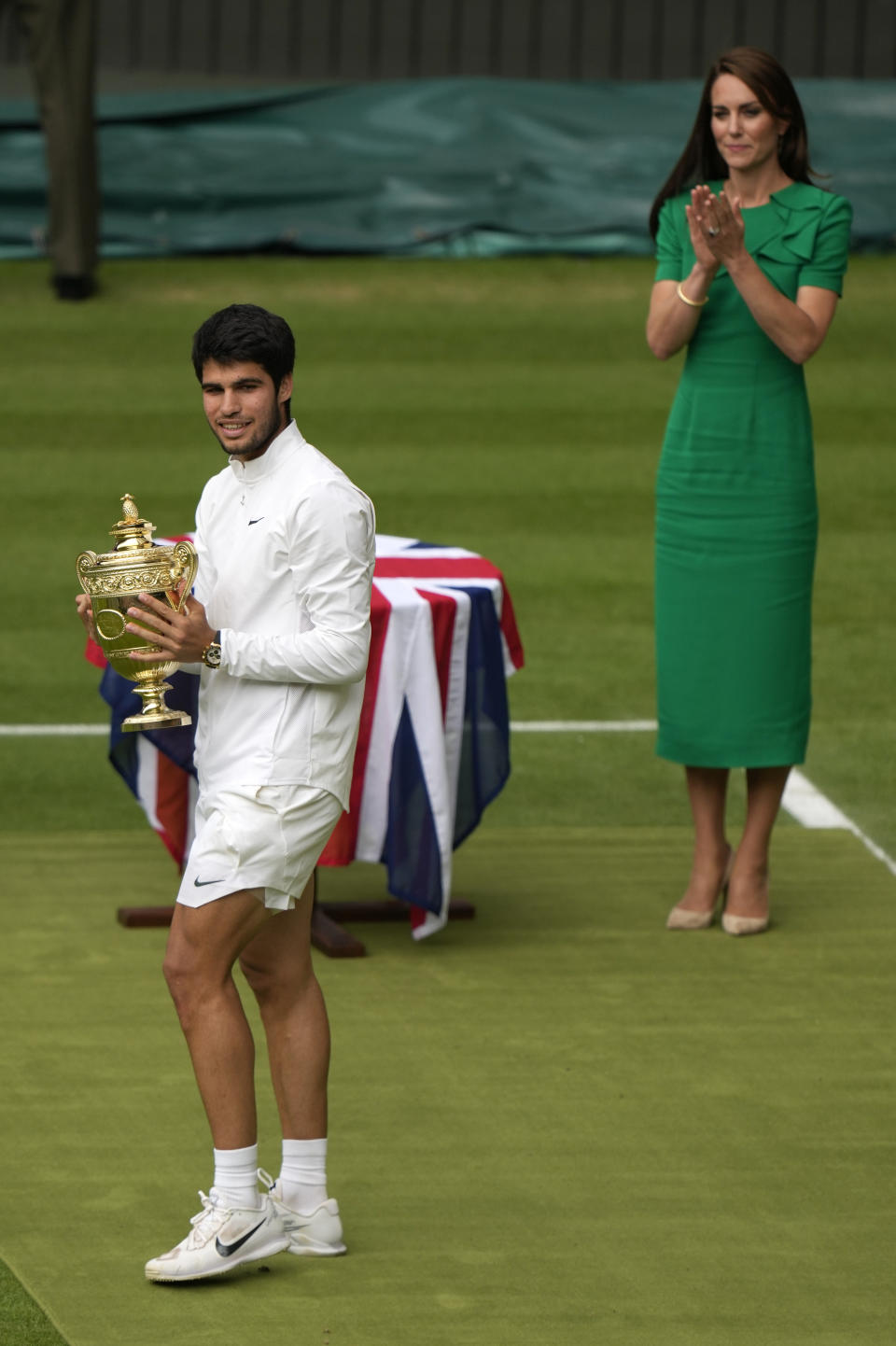 Spain's Carlos Alcaraz celebrates with the trophy after beating Serbia's Novak Djokovic to win the final of the men's singles on day fourteen of the Wimbledon tennis championships in London, Sunday, July 16, 2023. (AP Photo/Alastair Grant)