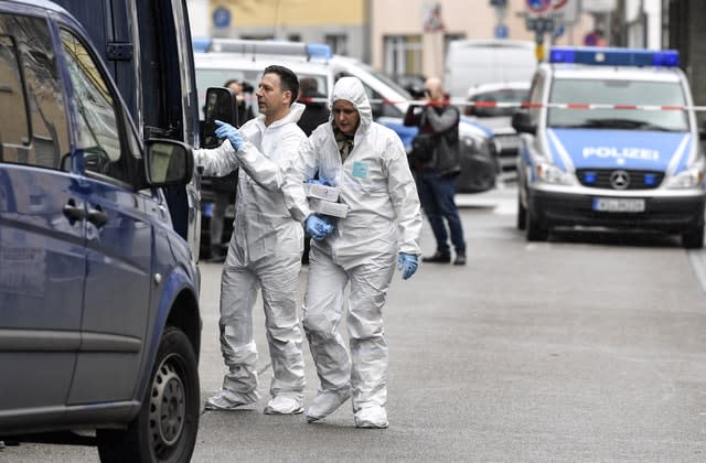 Forensic officers carry baskets from the hookah bar where several people were killed in Hanau, Germany 