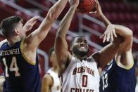 Boston College's Frederick Scott (0) shoots between Notre Dame's Nate Laszewski (14) and Nikola Djogo (13) during the second half of an NCAA college basketball game, Saturday, Feb. 27, 2021, in Boston. (AP Photo/Michael Dwyer)